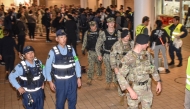 US miliary personnel join Japanese officials and residents for a one-off joint nighttime patrol on the streets of Okinawa City, Okinawa prefecture late on April 18, 2025, in the first such joint operation since 1973, following sexual assault cases involving US servicemen. (Photo by Hiroaki YAMASHIRO / AFP)
