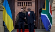 Ukraine's President Volodymyr Zelensky (left) is greeted by South Africa's President Cyril Ramaphosa during an official visit to South Africa, at the Union Buildings in Pretoria on April 24, 2024. (Photo by Phill Magakoe / AFP)