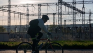 A cyclist rides near an electrical substation in Burgos on April 28, 2025, during a massive power cut affecting the entire Iberian peninsula and the south of France. Photo by CESAR MANSO / AFP.
