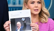 White House Press Secretary Karoline Leavitt holds a news article on Amazon CEO Jeff Bezos that reads 