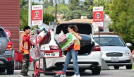 Target employees help load items into a vehicle for a customer pulled into a drive-up spot on April 28, 2025 in Alhambra, California. Photo by Frederic J. BROWN / AFP
