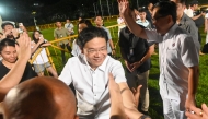 Singapore Prime Minister Lawrence Wong (2nd at R) of the People's Action Party (PAP) greets his supporters at the party's gathering centre during the general election results, in Singapore on May 3, 2025. (Photo by Roslan RAHMAN / AFP)