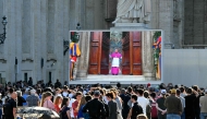 Faithful watch a giant screen displaying images of Diego Giovanni Ravelli, Master of Pontifical Liturgical Celebrations, closing the doors of the Sistine chapel as the conclave to elect a new Pope starts, at St Peter's Square in The Vatican, on May 7, 2025. (Photo by Andreas SOLARO / AFP)