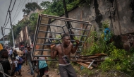 A man carries a window torn from a house during demolition in Kinshasa, Democratic Republic of Congo, on May 8, 2025. (Photo by Glody Murhabazi / AFP)
