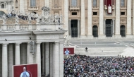 Faithfuls gather as Pope Leo XIV is seen on giant screens as he delivers the Regina Caeli prayer from the main central loggia of St Peter's basilica in The Vatican, on May 11, 2025. (Photo by Stefano Rellandini / AFP)