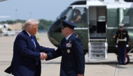 US President Donald Trump is greeted by Air Force Col. Paul R. Pawluk as he arrives to board Air Force One on May 12, 2025, at Joint Base Andrews, Maryland. Win McNamee/Getty Images/AFP 