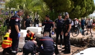 Emergency services assist a passerby injured after an old palm tree fell along the Boulevard de la Croisette, on May 17, 2025. (Photo by Miguel Medina / AFP)
 