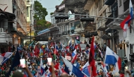 Workers carrying national flags take part in a protest against the government of President Jose Raul Mulino amid an indefinite strike in Panama City on May 23, 2025. (Photo by Martin Bernetti / AFP)