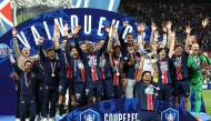 Paris Saint-Germain's Brazilian defender #05 Marquinhos (C) riases the trophy as he celebrates with teammates after winning French Cup final football match between Paris Saint-Germain (PSG) and Stade de Reims at the Stade de France in Saint-Denis, north of Paris, on May 24, 2025. (Photo by FRANCK FIFE / AFP)
