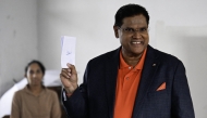Suriname's President Chandrikapersad Santokhi shows his ballot at a polling station during parliamentary elections in Paramaribo on May 25, 2025. (Photo by Juan Barreto / AFP)