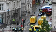 Police officers cover with an inflatable tent, behind a firefighter vehicle, the tents delimiting the scene of an incident in Water Street. (Photo by Paul Ellis / AFP)
 