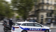 Photo used for representational purposes. A French police officer drives a police car next to a scooter on a street in Paris on April 16, 2025. Photo by Sébastien DUPUY / AFP.