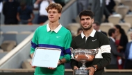 Winner Spain's Carlos Alcaraz (R) poses with the trophy next to Italy's Jannik Sinner at the end of their men's singles final match at the Roland-Garros Complex in Paris on June 8, 2025. (Photo by Thibaud Moritz / AFP)