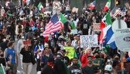 Demonstrators march in front of the Federal Building before curfew goes in effect in Los Angeles on June 10, 2025. (Photo by Robyn Beck / AFP)