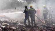 Firefighters working at the scene of the Air India flight crash. AFP file photo.