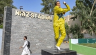 A commuter walks past the statue of Pakistan's former cricket player Wasim Akram outside the Niaz Stadium in Hyderabad on June 12, 2025. (Photo by Akram Shahid / AFP)