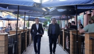 Onlookers wave as British Prime Minister Keir Starmer (R) and Canadian Prime Minister Mark Carney arrive at the Royal Oak pub in Ottawa, Canada, on June 14, 2025 to watch the Stanley Cup Final ice hockey match on television, ahead of the G7 leaders' summit. (Photo by Stefan Rousseau / POOL / AFP)
