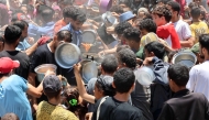 Palestinians try to get food at a charity kitchen providing hot meals in Rimal neighbourhood in Gaza City on June 18, 2025. Photo by Omar AL-QATTAA / AFP