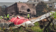An investigation team inspects the wreckage of Air India flight 171 a day after it crashed in a residential area near the airport, in Ahmedabad on June 13, 2025. Photo by Sam PANTHAKY / AFP.

