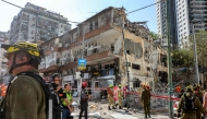 First responders walk outside a heavily-damaged building at the site of an Iranian missile attack in Ramat Gan in central Israel near Tel Aviv, on June 19, 2025. (Photo by GIL COHEN-MAGEN / AFP)
