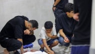 People mourn over the body of a loved one at the morgue of Al-Awda hospital, in Nuseirat camp in central Gaza on June 20, 2025, after several Palestinians were killed as they reportedly headed to a food distribution centre in the war-stricken Gaza Strip. Photo by AFP