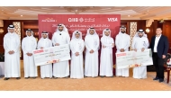 QIIB officials with winners of the promotion campaign.
