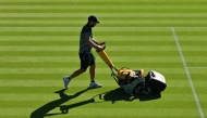 A member of the groundstaff mows the grass on a court on the first day of the 2025 Wimbledon Championships at The All England Lawn Tennis and Croquet Club in Wimbledon, southwest London, on June 30, 2025. (Photo by Glyn KIRK / AFP)
