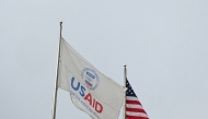 (FILES) A USAID and American flag fly before Congressional Democrats hold news conference outside of United States Agency for International Development (USAID) headquarters in Washington, DC, on February 3, 2025. (Photo by Mandel NGAN / AFP)