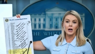 White House Press Secretary Karoline Leavitt, holding up a sheet showing global interest rates and a message from US President Donald Trump to Federal Reserve Chair Jerome Powell, speaks during the daily briefing in the Brady Briefing Room of the White House in Washington, DC, on June 30, 2025. (Photo by ANDREW CABALLERO-REYNOLDS / AFP)
