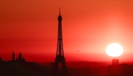 Photo used for representational purposes. The sun rises by the Eiffel Tower and the Sacre Coeur Basilica ontop of the Montmartre hill in Paris on July 1, 2025, as the city is on red alert for high temperatures, with the top of the Eiffel Tower shut, polluting traffic banned and speed restrictions in place as a searing heatwave gripped Europe. Photo by Thibaud MORITZ / AFP.