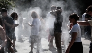People cool off with misters in a park in the Halles district of Paris on July 1, 2025, as a heatwave hits France. (Photo by Thibaud MORITZ / AFP)
