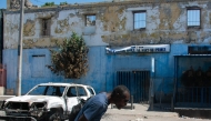 A man leaves the prison area and lowers his head because of the nearby gunfire, in Port-au-Prince, Haiti, March 4, 2024. (Photo by Clarens SIFFROY / AFP)
