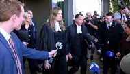 Lead barrister Colin Mandy (R) is approached by members of the media as he leaves the Latrobe Valley Magistrates' Court with Barrister Sophie Stafford (C) and Lawyer Ophelia Holloway (L) in Morwell on July 7, 2025. Photo by WILLIAM WEST / AFP.