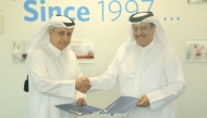 QCS Chairman Dr. Khalid bin Jabor Al Thani and Director of Al-Khaldi Law Firm Saleh Ali Al-Khaldi exchanging documents after signing the agreement.