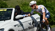 Team TotalEnergies' French rider Emilien Jeanniere cycles alongside the medical assistance vehicle during the 4th stage of the 112th edition of the Tour de France cycling race, 174.2 km between Amiens Metropole and Rouen, Northern France, on July 8, 2025. (Photo by Marco BERTORELLO / AFP)
