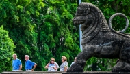 Tourists walk past a stone lion at the Independence Memorial Hall, built to commemorate Sri Lanka's independence from British rule, in Colombo on July 1, 2025. (Photo by Ishara S. KODIKARA / AFP)
