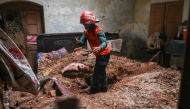 A rescue worker clears debris from a collapsed roof after heavy monsoon rains in Lahore on July 10, 2025 (Photo by Arif ALI / AFP)
