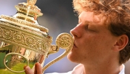 Italy's Jannik Sinner kisses the winner's trophy as he poses for pictures following his victory against Spain's Carlos Alcaraz at the end of their men's singles final tennis match on the fourteenth day of the 2025 Wimbledon Championships at The All England Lawn Tennis and Croquet Club in Wimbledon, southwest London, on July 13, 2025. (Photo by Kirill KUDRYAVTSEV / AFP) / RESTRICTED TO EDITORIAL USE
