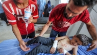 An injured boy is brought for treatment at Al-Awda Hospital in the Nuseirat camp for Palestinian refugees in the central Gaza Strip on July 16, 2025. (Photo by Eyad BABA / AFP)
