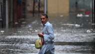 A man wades through a flooded street during heavy monsoon rains in Rawalpindi on July 17, 2025. Photo by Aamir QURESHI / AFP