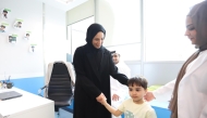 Minister of Social Development and Family H E Buthaina bint Ali Al Jabr Al Nuaimi interacting with a child during the launch of Early Intervention Program for children with Autism Spectrum Disorder yesterday.