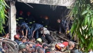 Bangladesh's fire service and security personnel conduct a search and rescue operation after a Air Force training jet crashed into school in Dhaka on July 21, 2025. (Photo by Abdul Goni / AFP)
 