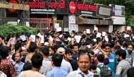 Blood donors gather outside a hospital with documents after an Air Force training jet crashed into a school in Dhaka on July 21, 2025. (Photo by Munir UZ ZAMAN / AFP)