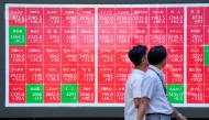 Pedestrians walk past an electronic quotation board displaying the Nikkei 225 stock prices on the Tokyo Stock Exchange in Tokyo on July 23, 2025. Photo by Kazuhiro NOGI / AFP.