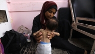 File photo of a Palestinian mother holding her two year old daughter.