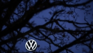 The logo of German carmaker Volkswagen (VW) is seen behind a tree at the company's headquarters in Wolfsburg, central Germany, on December 4, 2024. Photo by Ronny HARTMANN / AFP