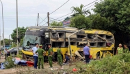 This handout photograph taken and released by the Vietnam News Agency (VNA) on July 25, 2025 shows security personnel along with authorities standing next to a crashed bus in Ha Tinh province, Central Vietnam. (Photo by Vietnam News Agency / AFP)