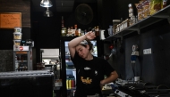 A catering employee wipes her face as she works in a small street-facing restaurant during a heatwave in Thessaloniki on July 24, 2025. (Photo by Sakis Mitrolidis / AFP)

