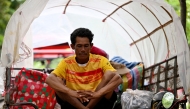 A villager who fled his home near the Cambodia-Thailand border sits on a cart on the grounds of a pagoda in Oddar Meanchey province on July 25, 2025. Photo by TANG CHHIN Sothy / AFP.