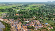 An aerial view shows people, who fled their homes near the border area between Cambodia and Thailand, taking shelter near a pagoda in Oddar Meanchey province on July 26, 2025. (Photo by Suy Se / AFP)
